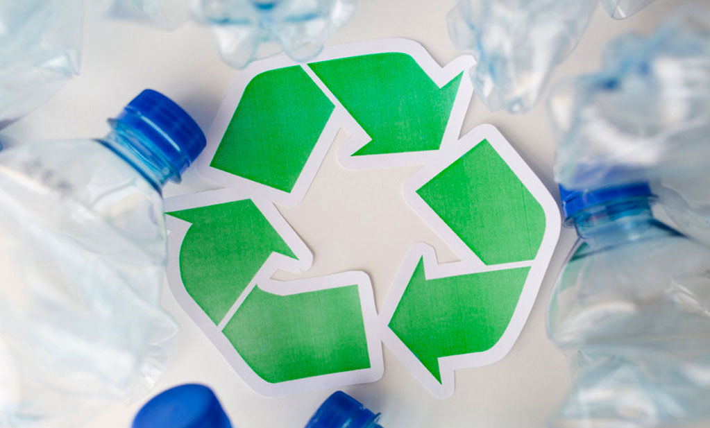 Recycling logo tussen lege plastic flessen