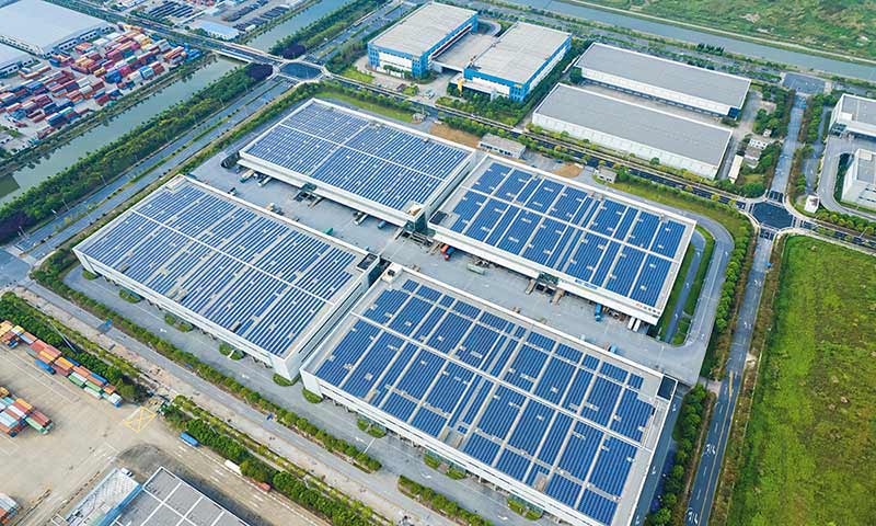 Magazijnen in een industrieterrein met een daken vol zonnepanelen voor een groenere logistiek