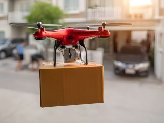 Rode drone vervoert pakketje in de straten